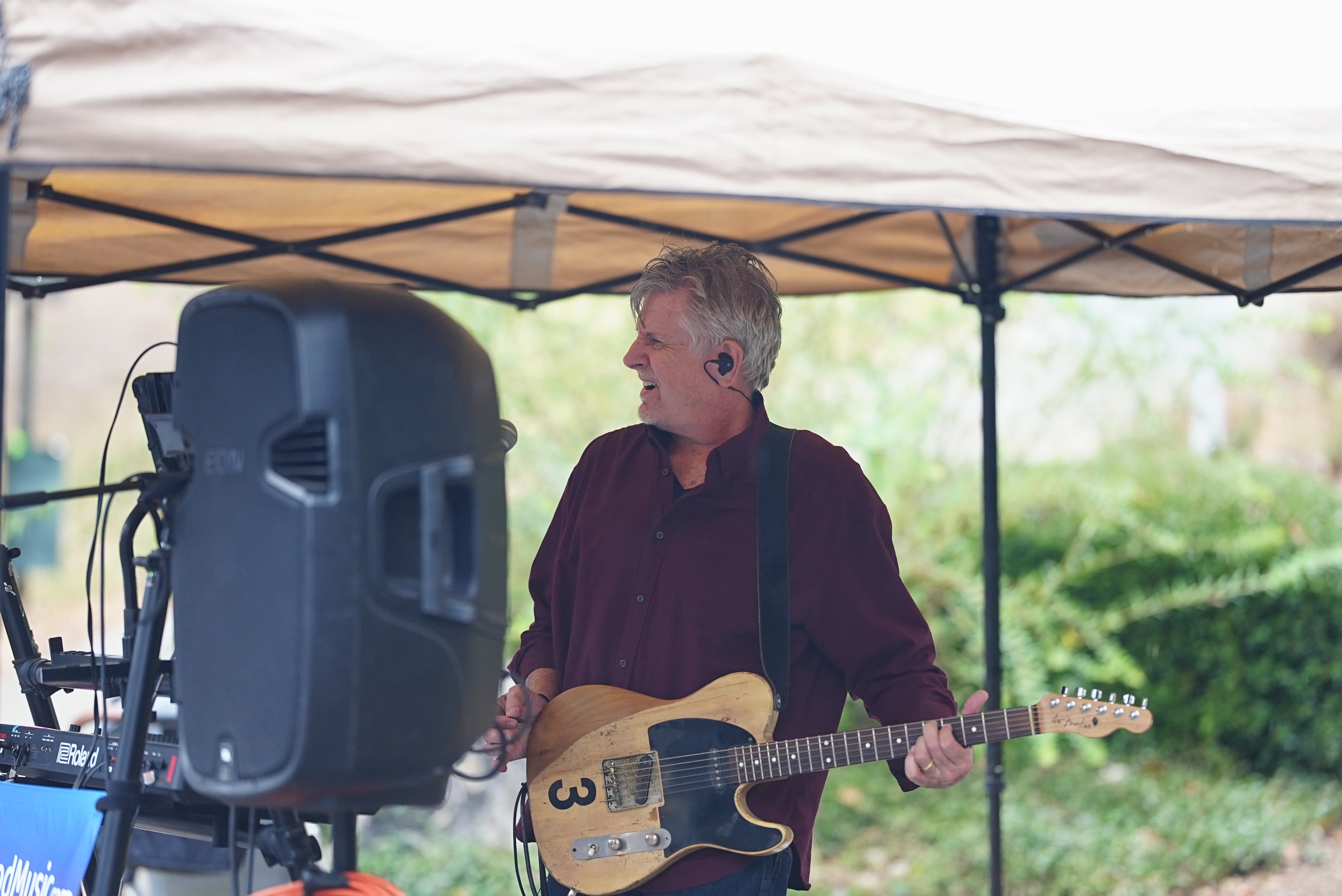 Mike McLeod performing outdoors under a tent with his Telecaster