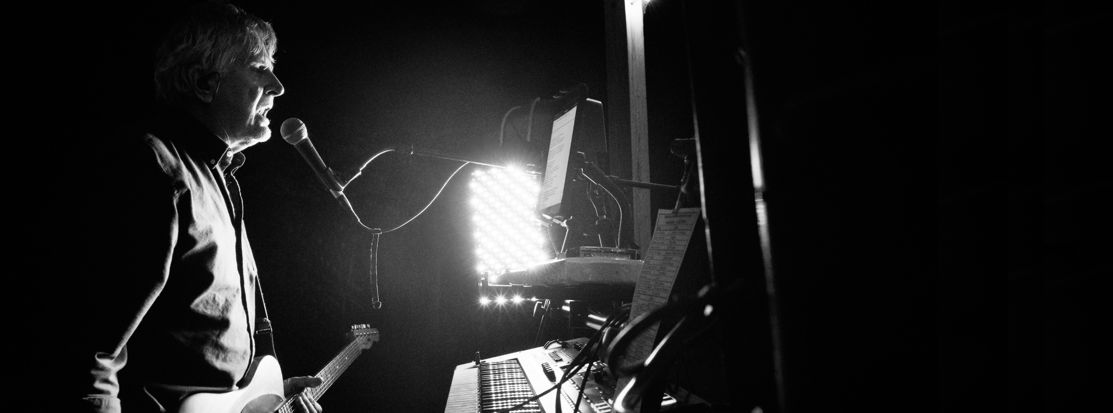 Mike McLeod performing live with dramatic stage lighting in Macon